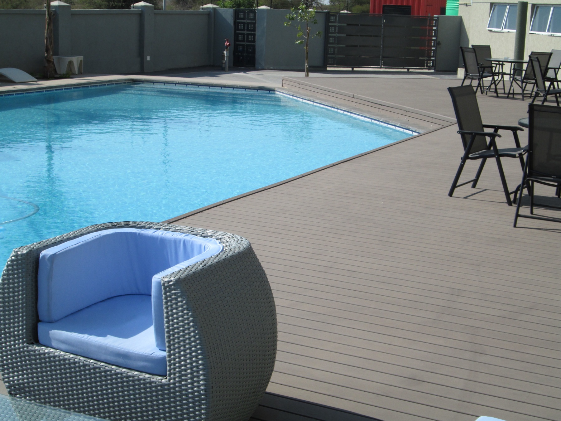 Wooden pool deck with lounge chairs and parasols at Aquarian Tide Hotel